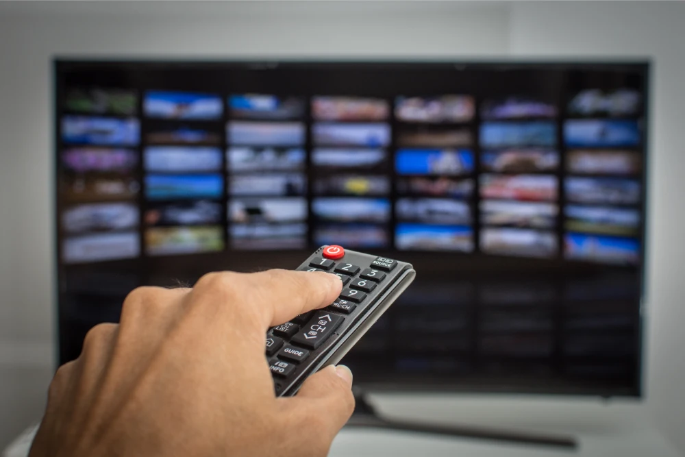 close up shot of a person holding a controler and navigating his 3 month IPTV Subscription